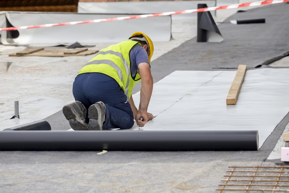 Waterproofing and insulation at construction site, waterproofing membrane preventing water penetration. Exterior vapor barrier for foundations and basements.